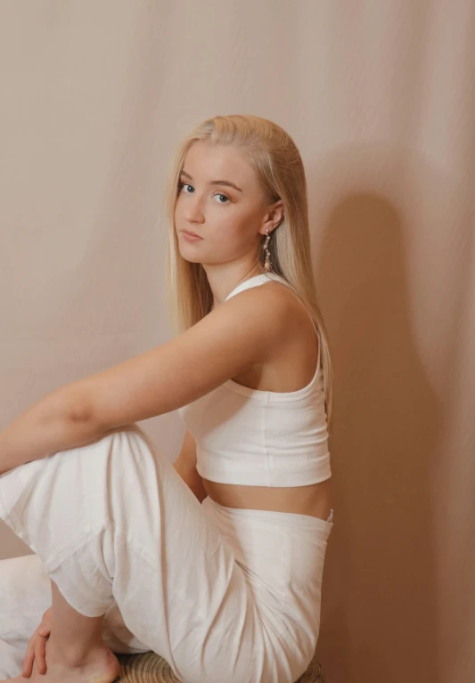 young blond woman sitting on the bed, posed for the camera