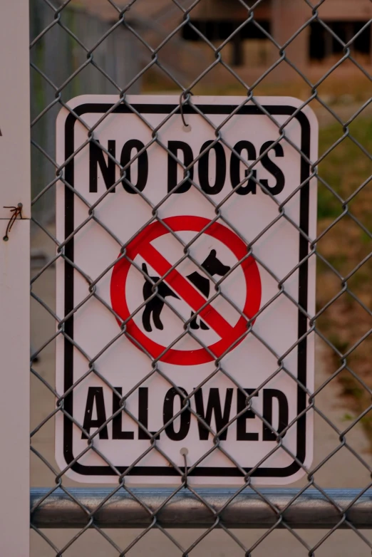 there is a sign that says no dogs allowed on the fence