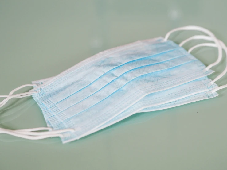 a row of blue face masks on top of a table