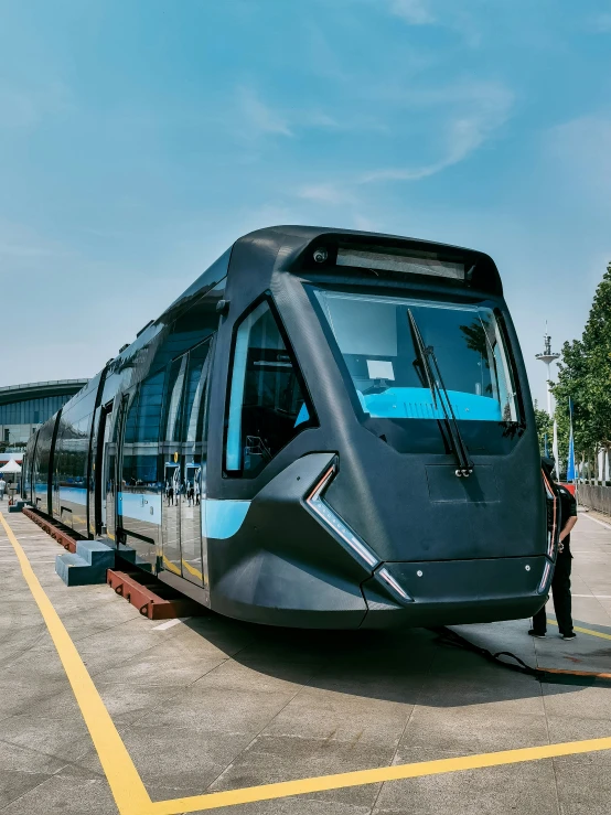 a grey and blue train on a track with a man