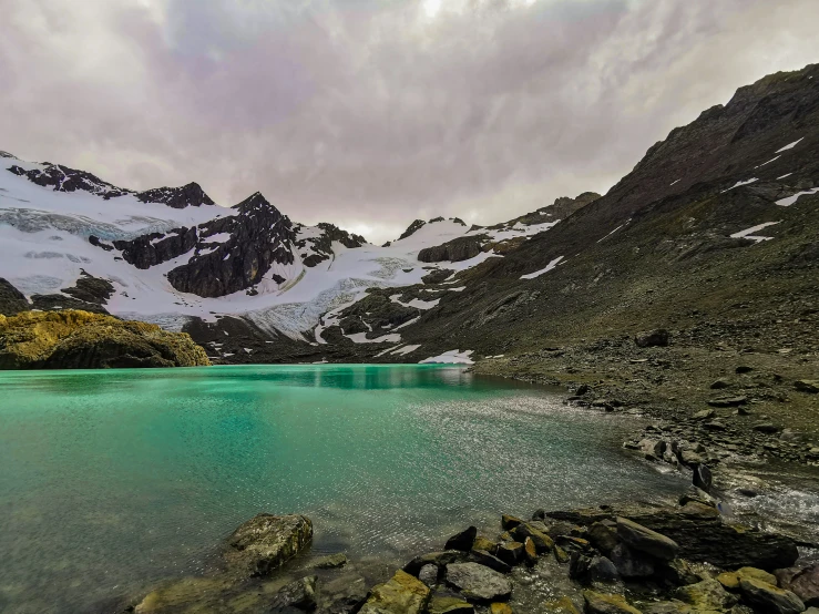 a mountain landscape with a clear lake surrounded by rocks