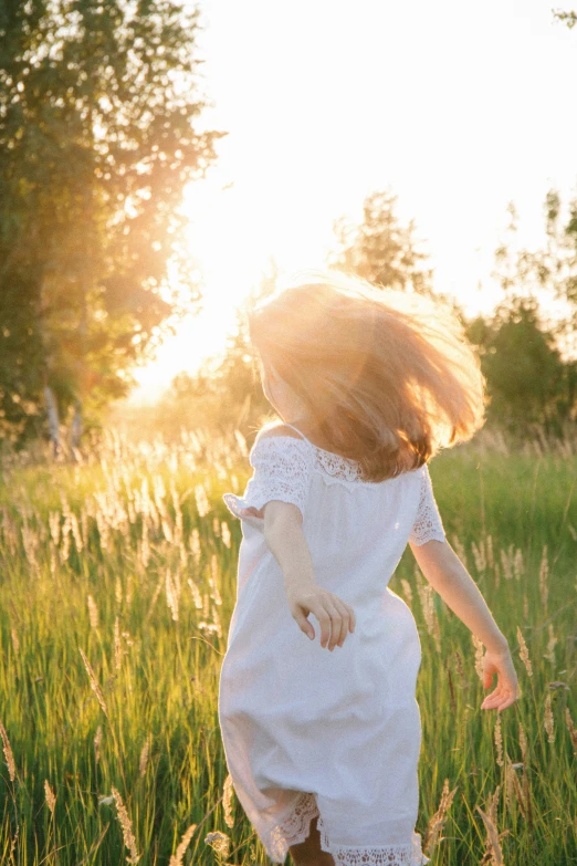 a  running through a green field with long hair