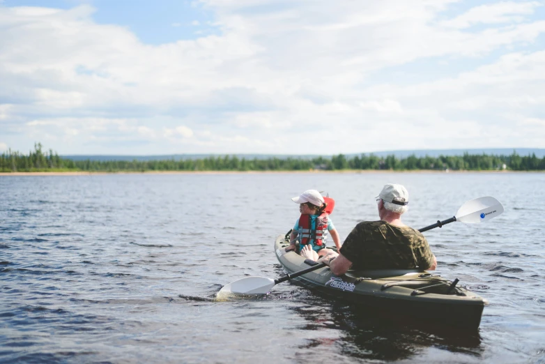 an older couple canoe boarding on a lake