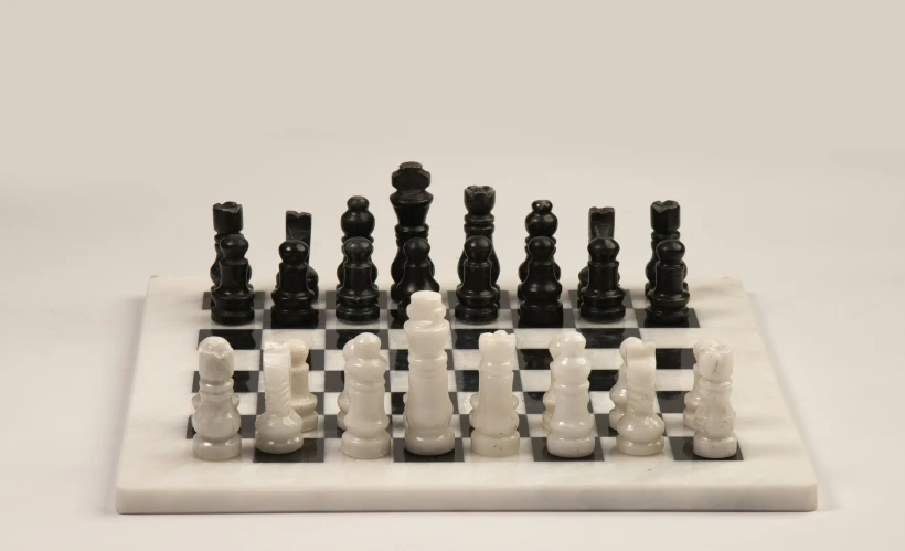 a set of chess pieces sits on a marble board