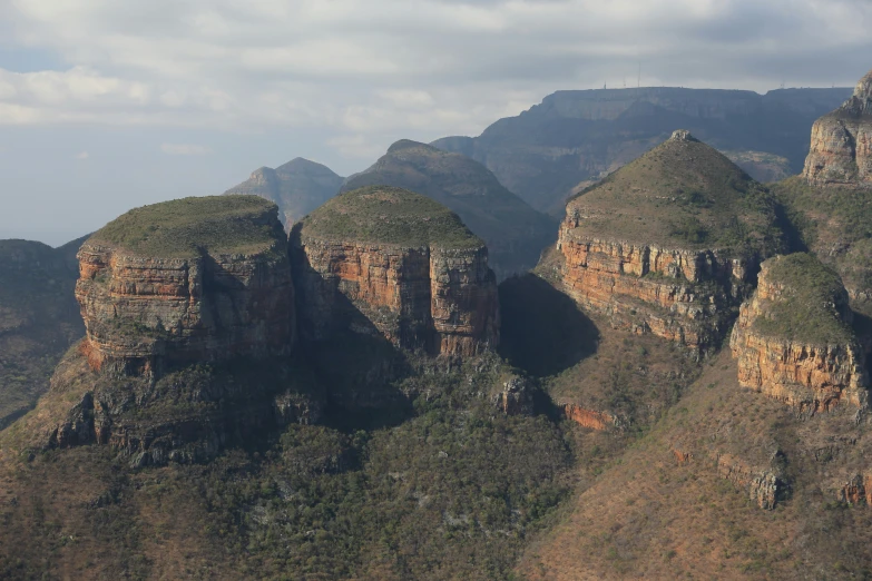 a group of large rock formations next to mountains