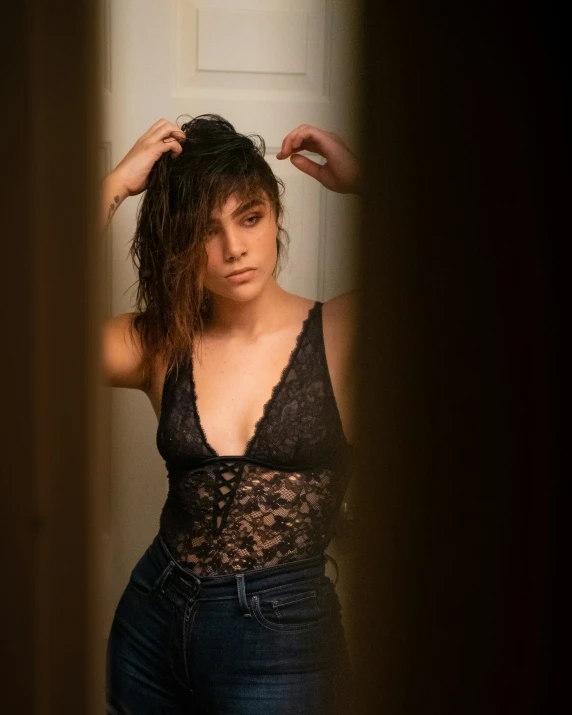 a woman holding her hair and posing in a room