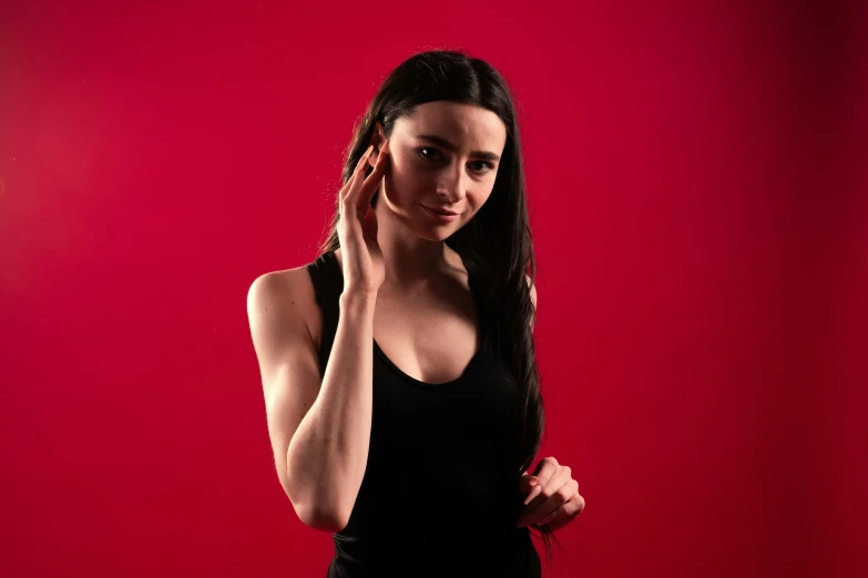 a woman posing with her hands to her ear