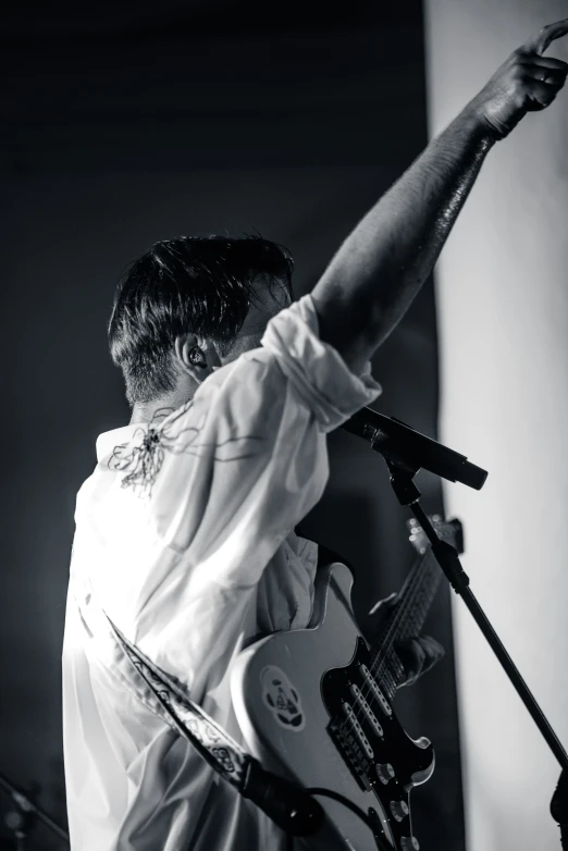 a woman with an electric guitar standing in front of a microphone