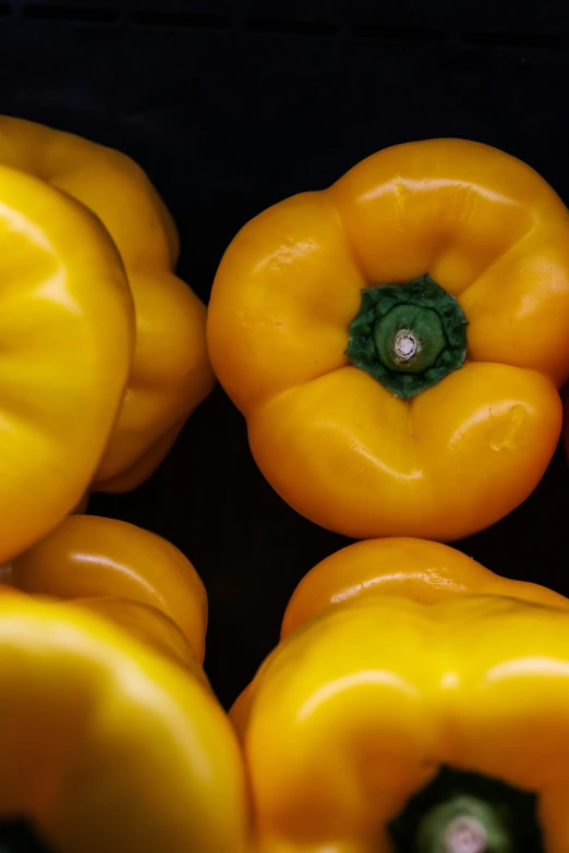 several yellow bell peppers piled on top of each other