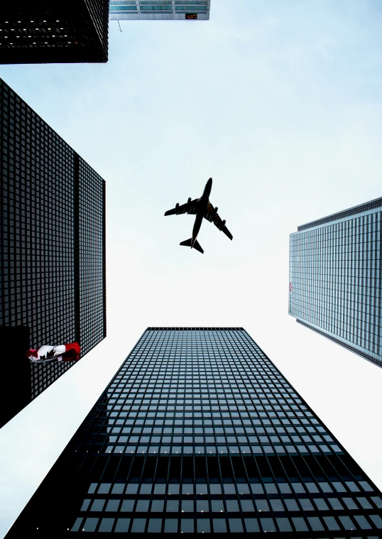 a plane is flying low above a bunch of tall buildings