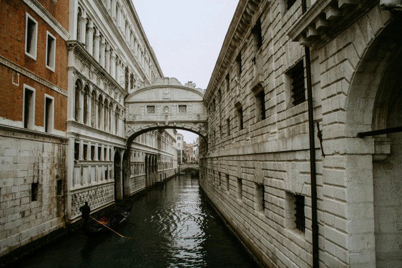 a boat floats under a bridge in a canal