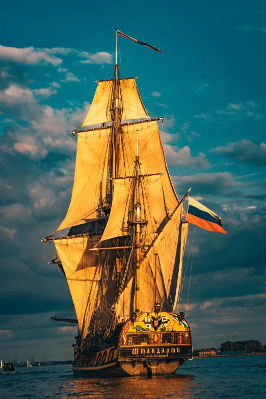 a sail boat floating on the water with sails down