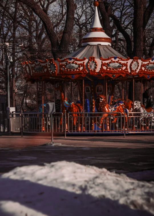 the merry go round is surrounded by large trees