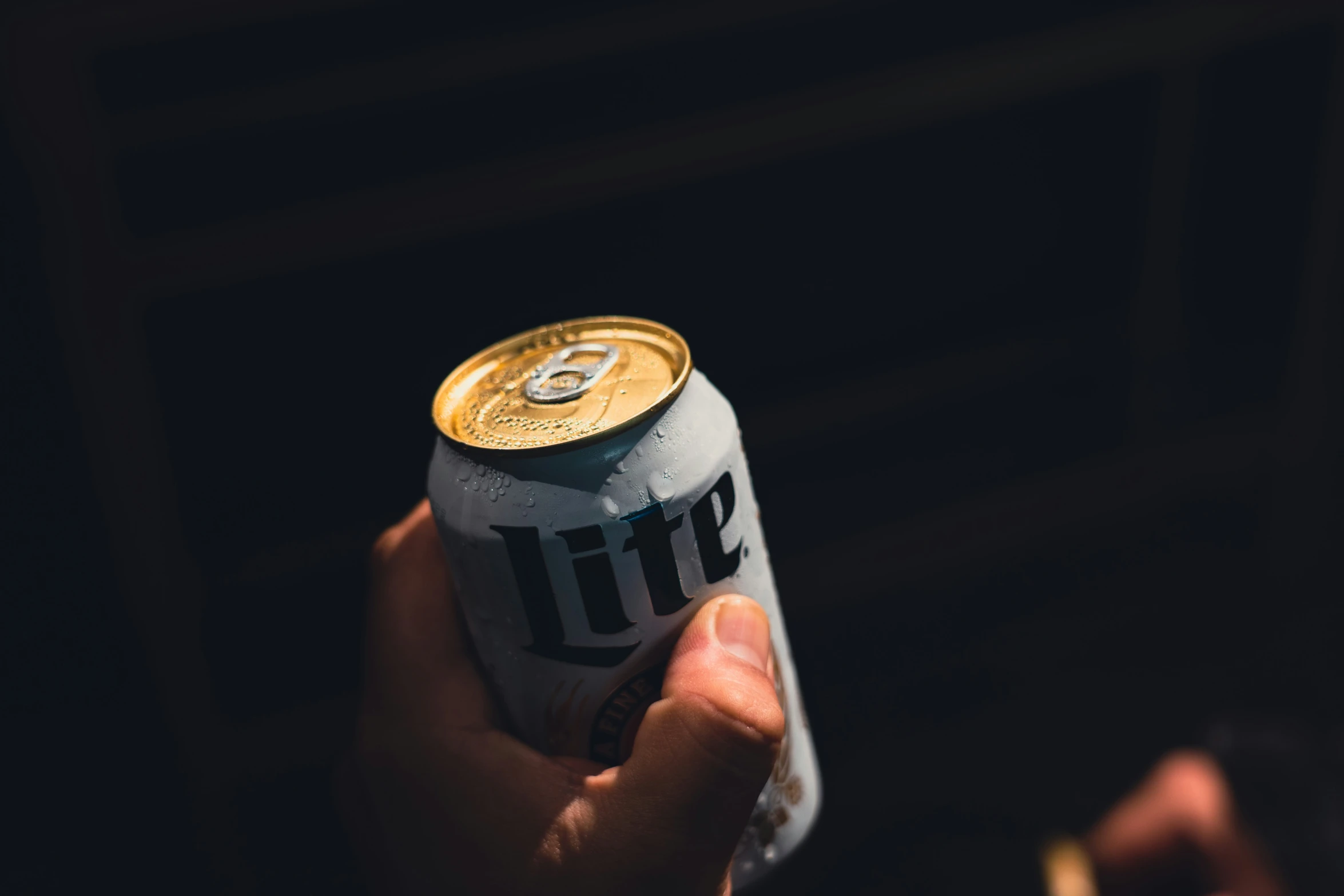 a can with a white and black design is held by someone