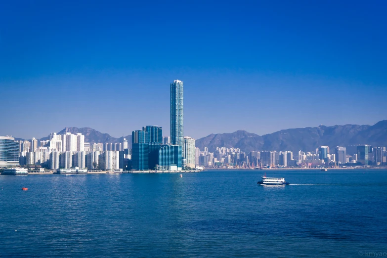 a boat is floating through a calm bay by a high rise building