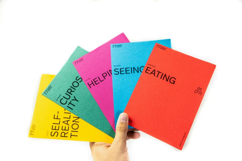 person holding four books in front of the camera