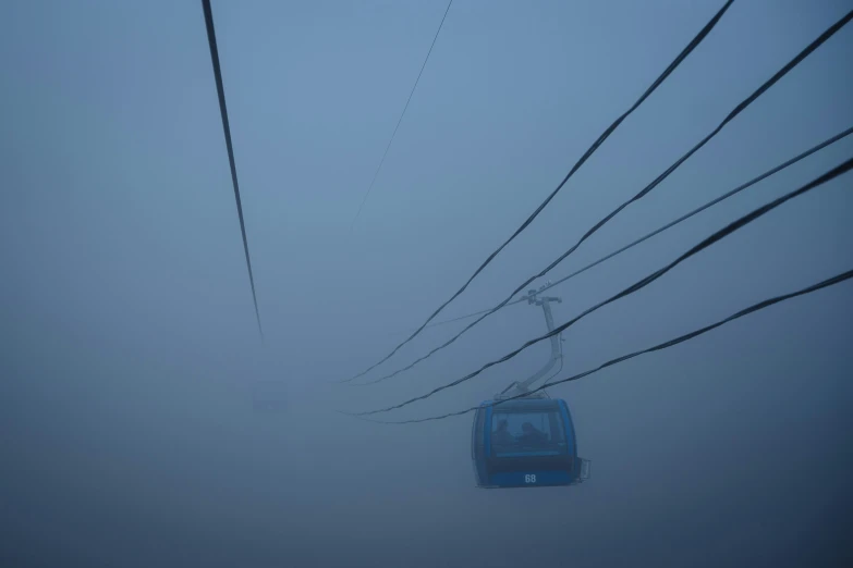 a chairlift suspended over a foggy landscape