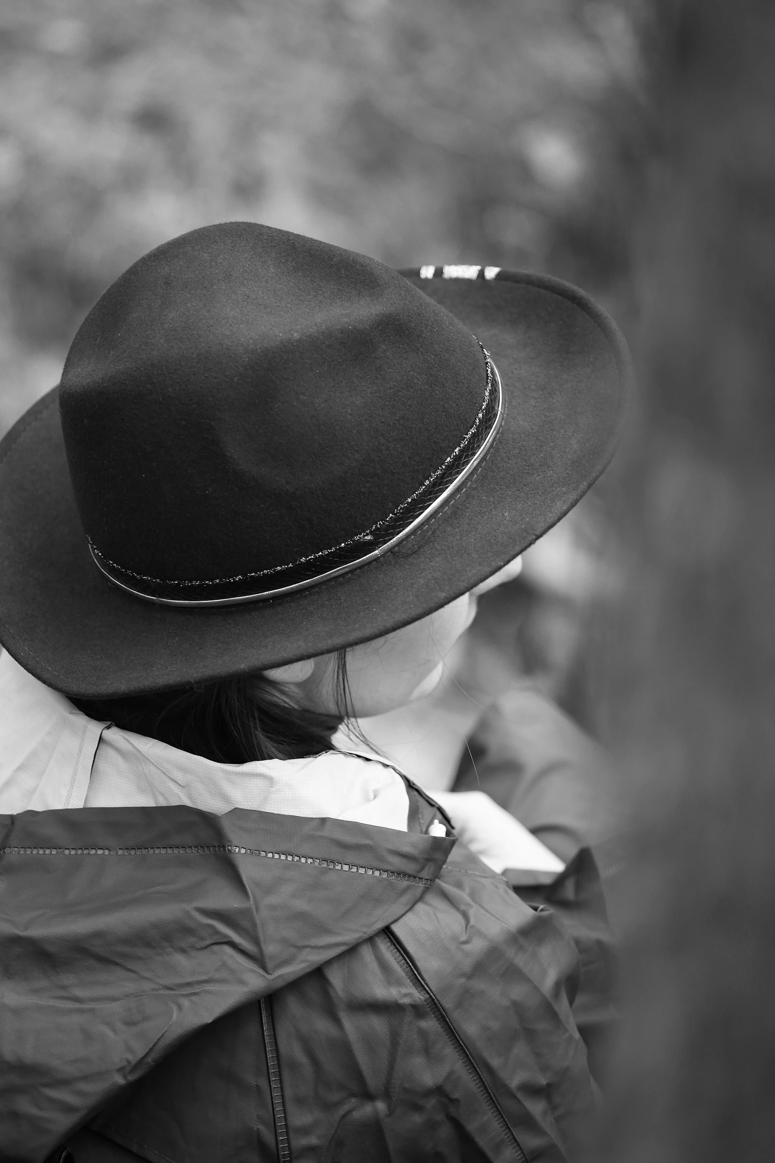 a man in a hat stares out at the woods