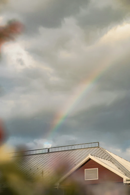 a rainbow appears in the sky over a house