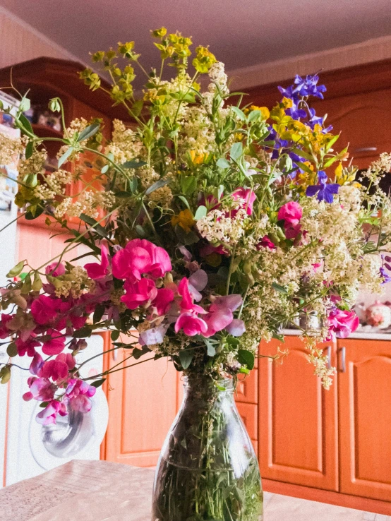 a vase filled with lots of flowers sitting on a table