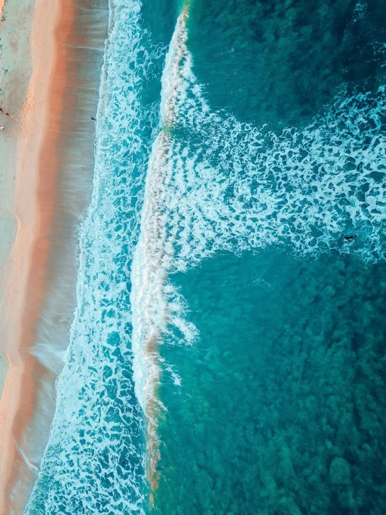 an aerial view of the water and beach with waves