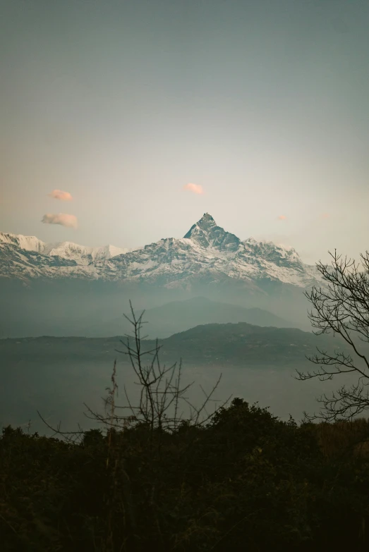 a mountain covered with snow covered hills and trees