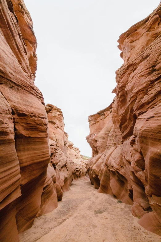 a man riding a horse through a narrow canyon in a desert