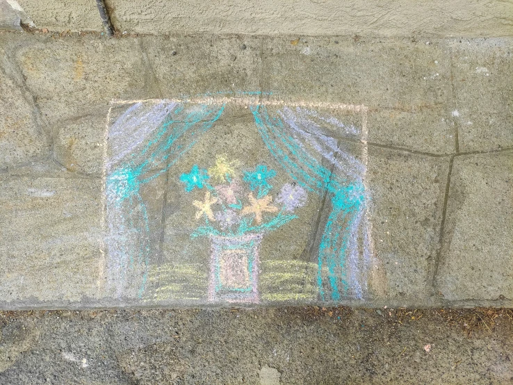 a colorful drawing on the ground of an area where pavement is covered in cement