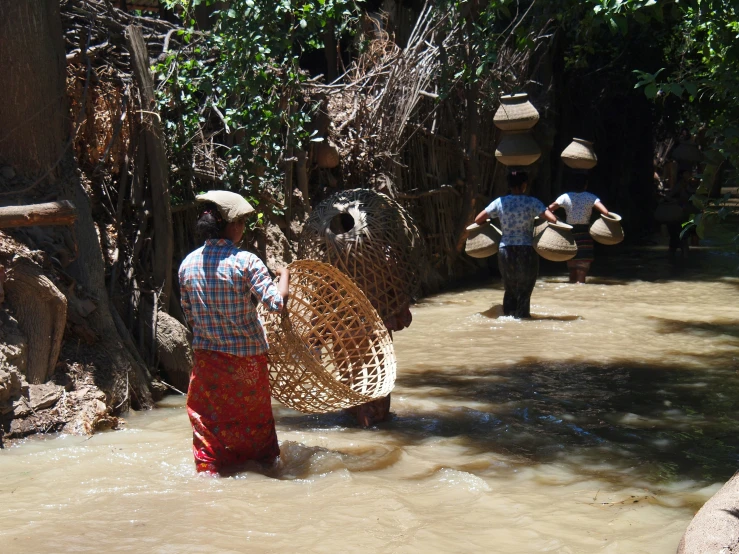 a group of people in water with baskets and water pumps