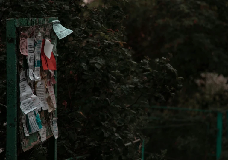 a bulletin board on a fence outside in the snow