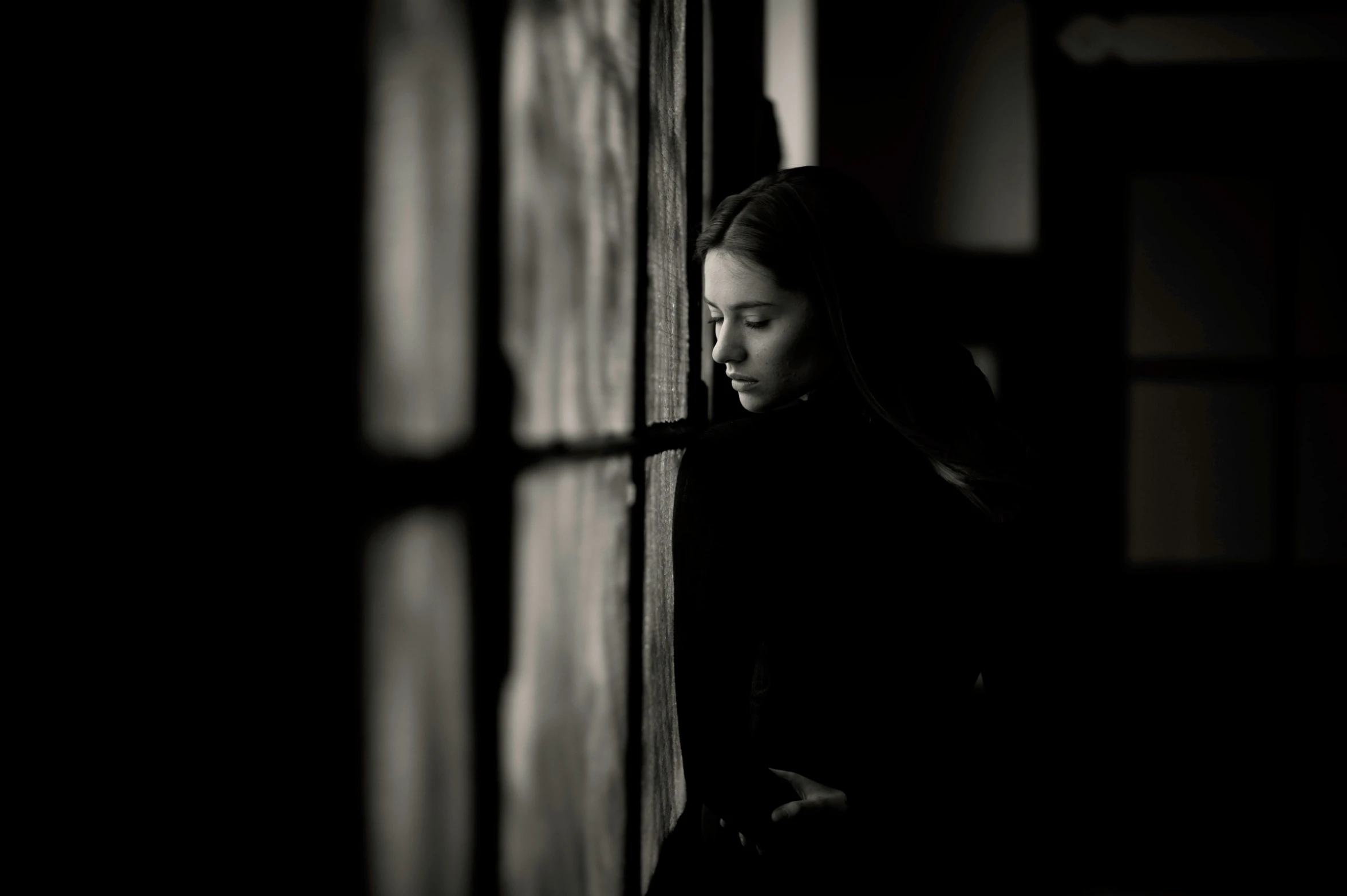 a woman standing against a wall in a dark room