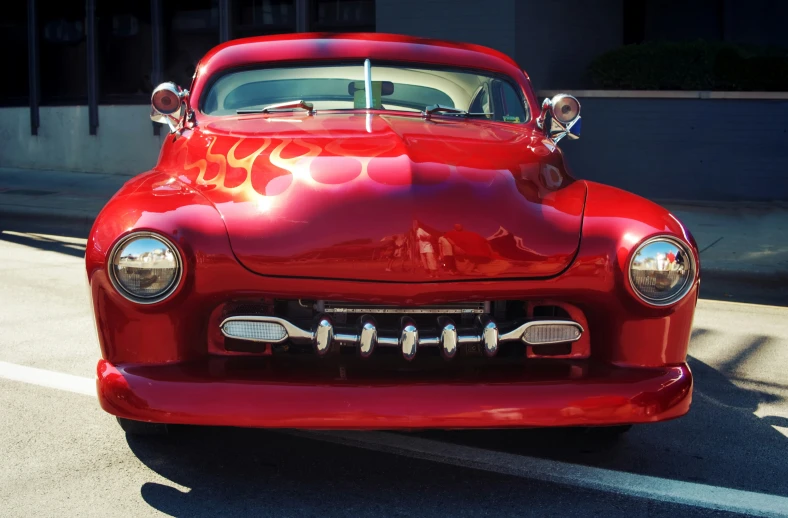 an old fashioned red car in the sun