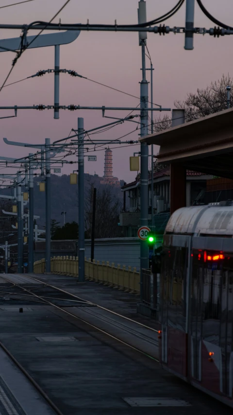 the sun is setting as a train moves down the tracks