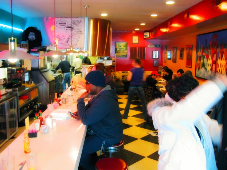 people are seated in a diner eating food