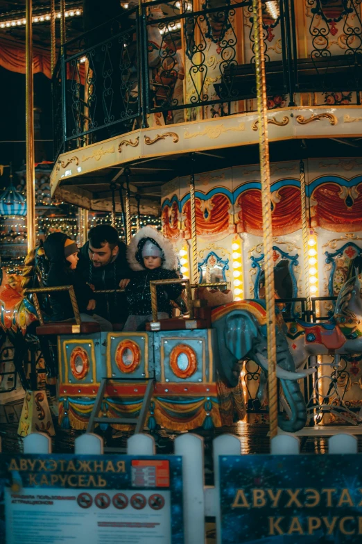 an image of a family riding on a carousel at an amut park