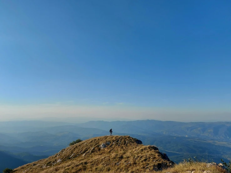 a person standing on the top of a hill with no shoes