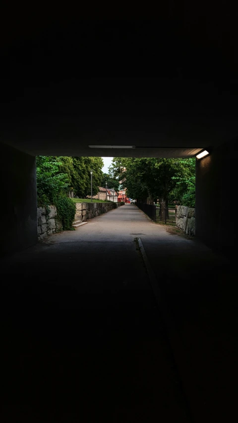 a person rides down a dark alley with a car coming out