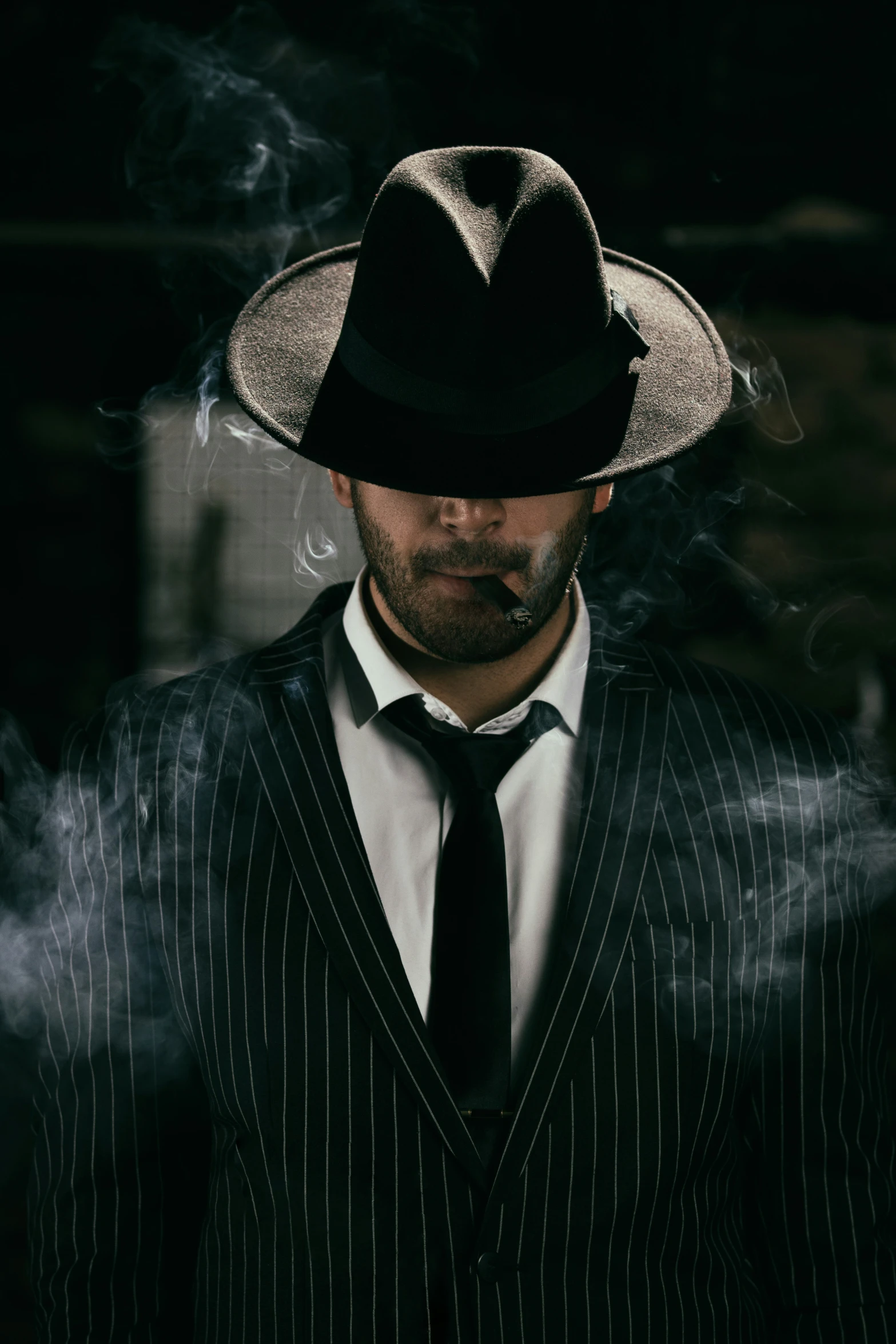 a man in a suit and hat smoking cigar