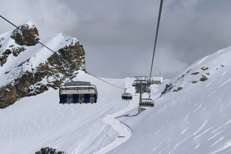 a ski lift going over snow covered ground