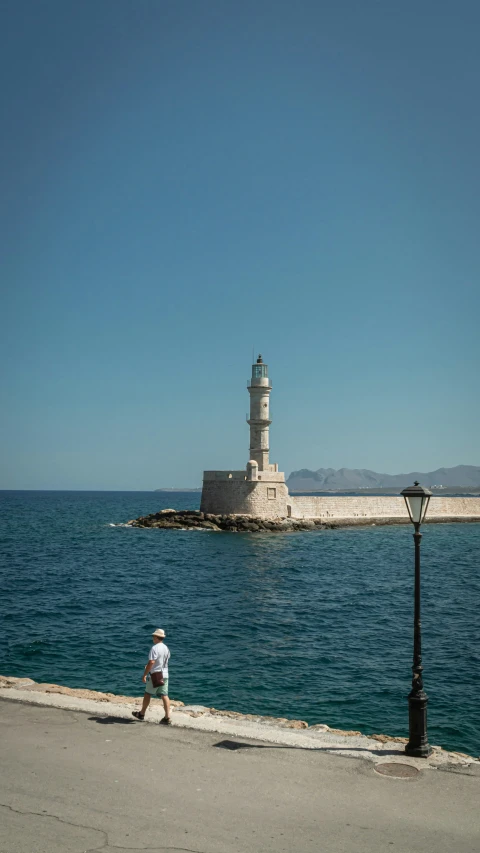 an old man is sitting by the water