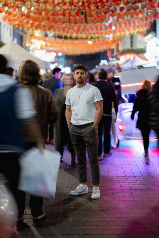 a man is standing on a sidewalk surrounded by people