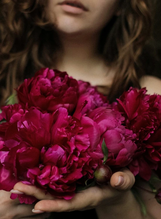 woman with wavy hair holding bunch of flowers