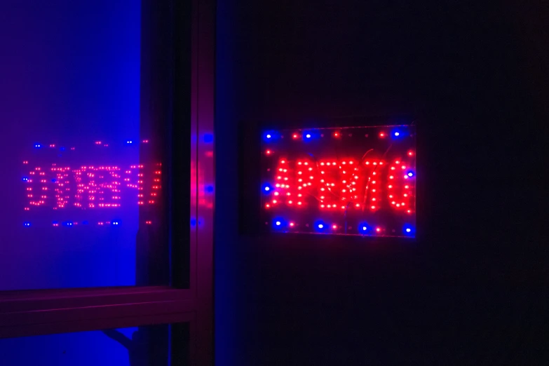 a sign is lit up in red, blue and purple