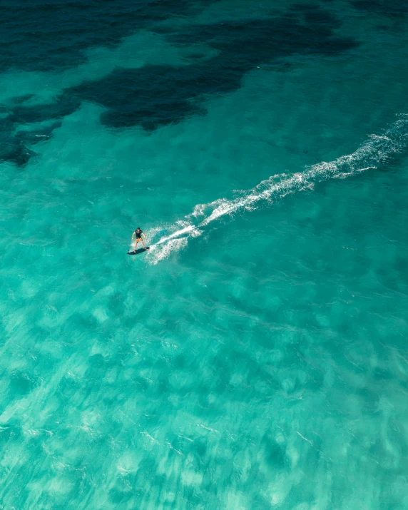 the woman is out in the blue water on the water ski