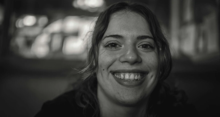 a young woman is smiling in front of some lights