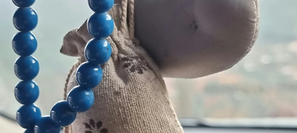 an odd looking blue bead necklace hangs out the window