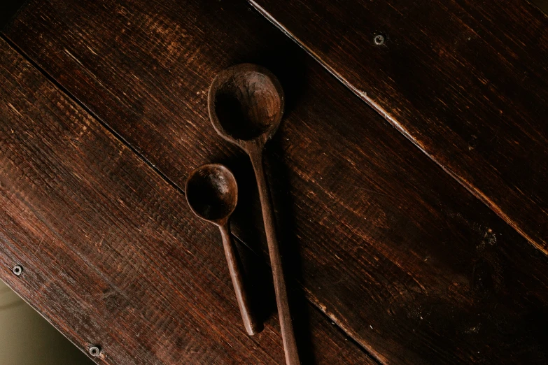 three spoons placed next to an old wooden cupboard