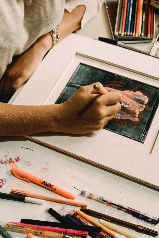 a woman's hand is on a painting on paper