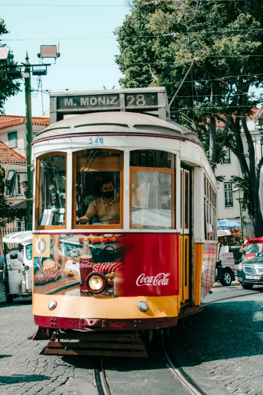 a trolley is coming down the street on tracks