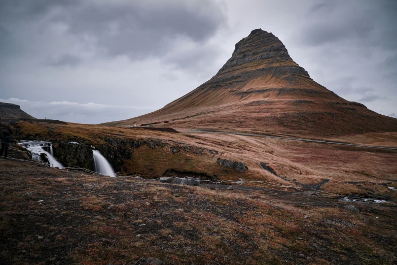 a mountain with a small waterfall coming down it